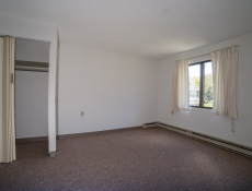 Large empty bedroom with closet space and larger window